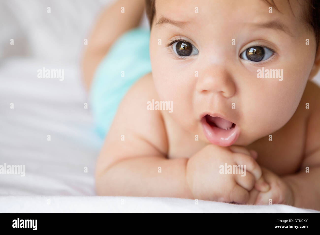 Baby girl laying on bed Stock Photo Alamy