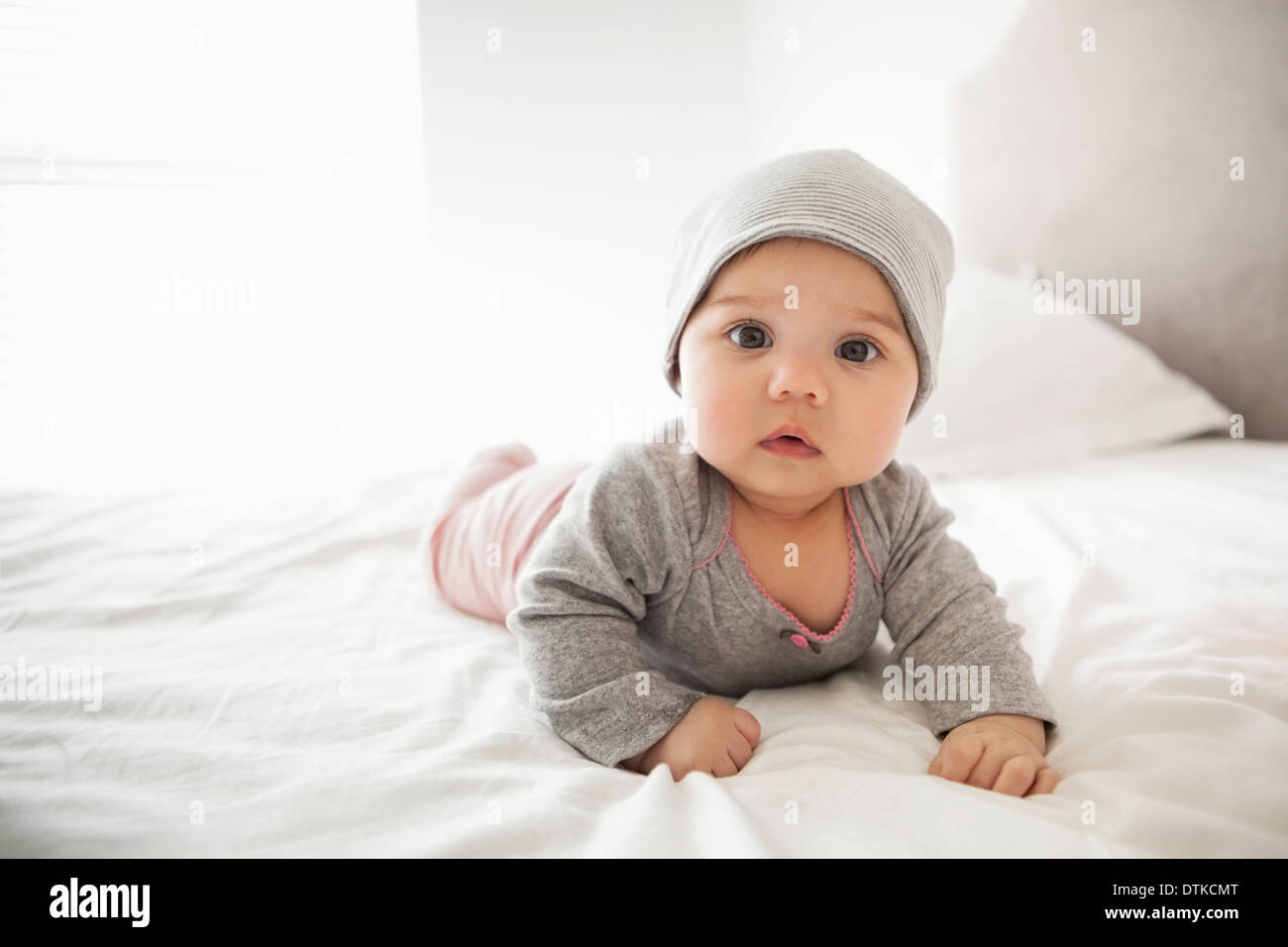 Baby girl laying on bed Stock Photo
