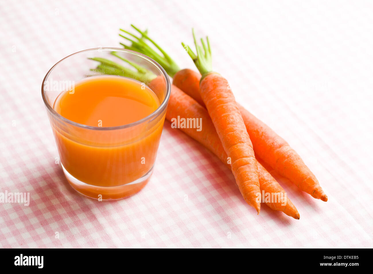 carrot juice in glass on checkered tablecloth Stock Photo