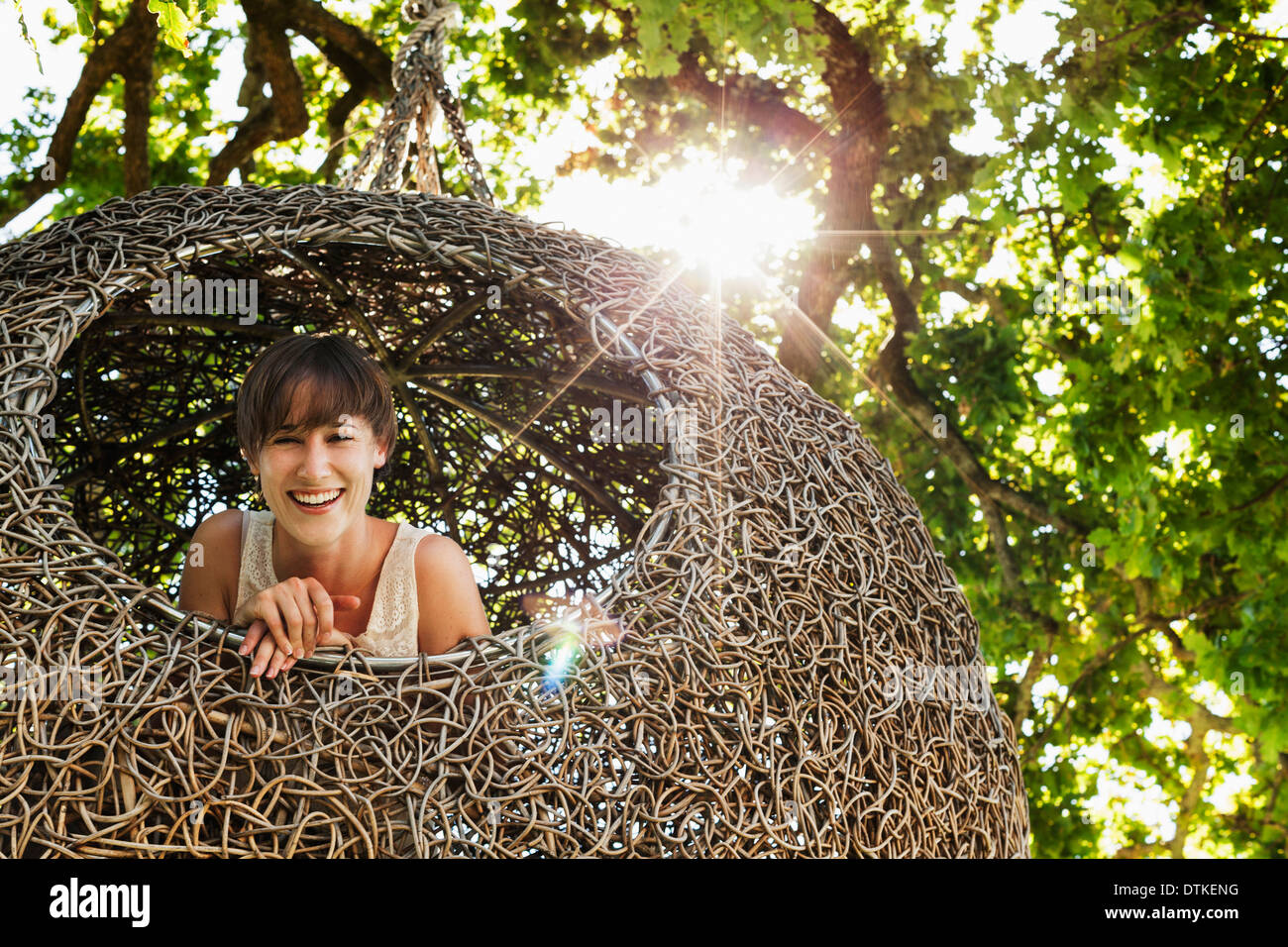 Woman smiling in nest tree house Stock Photo