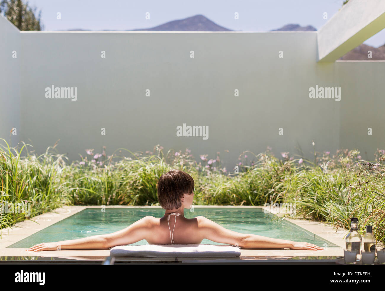 Woman relaxing in luxury lap pool Stock Photo