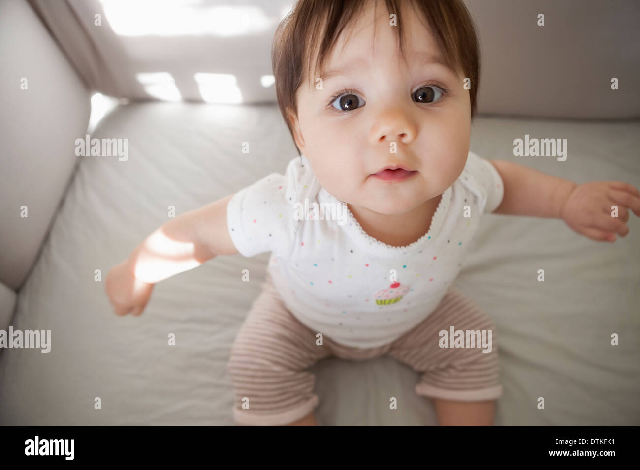Baby girl sitting up in crib Stock Photo Alamy
