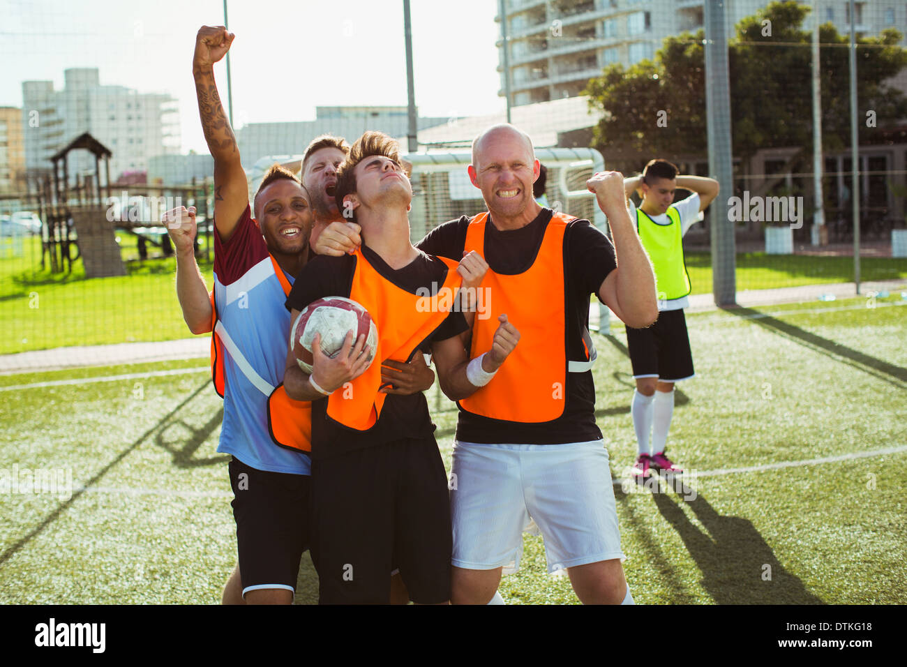 Soccer players cheering on field Stock Photo