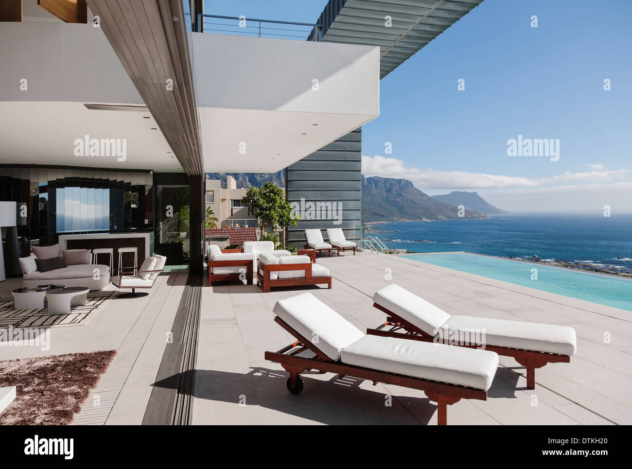 Modern patio and infinity pool overlooking ocean Stock Photo