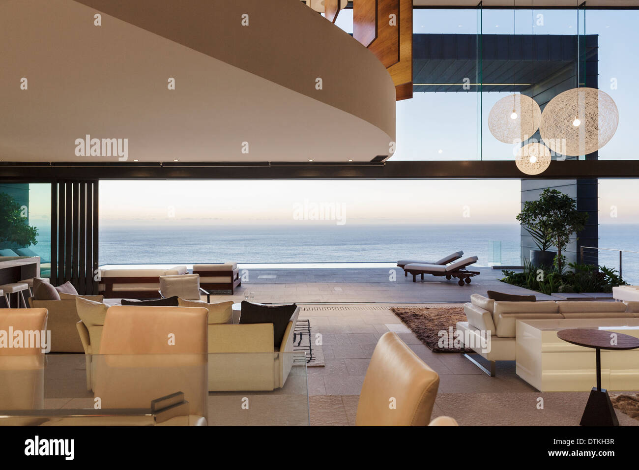 https://c8.alamy.com/comp/DTKH3R/modern-living-room-overlooking-ocean-at-sunset-DTKH3R.jpg