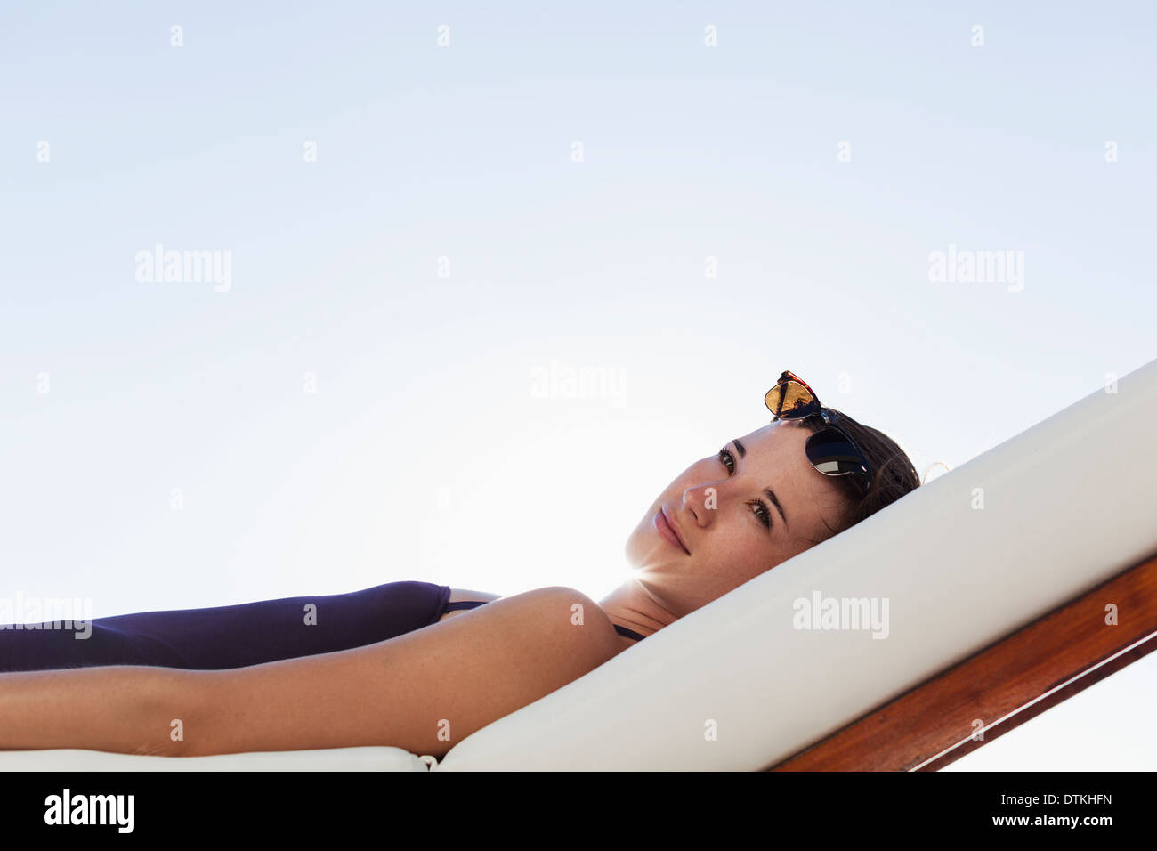 Woman lying on lounge chair hi-res stock photography and images - Alamy