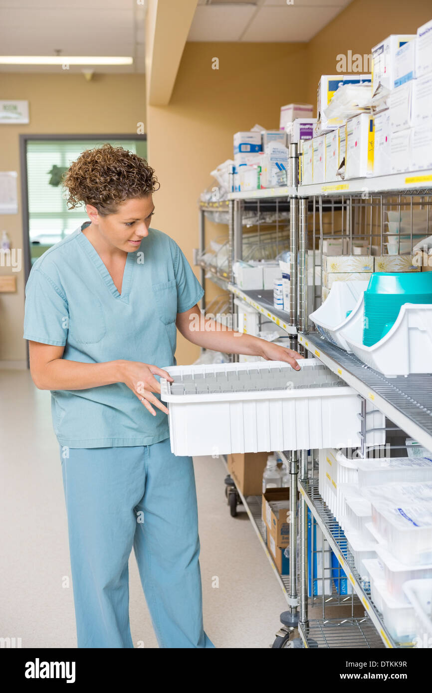 Nurse Arranging Container In Storage Room Stock Photo