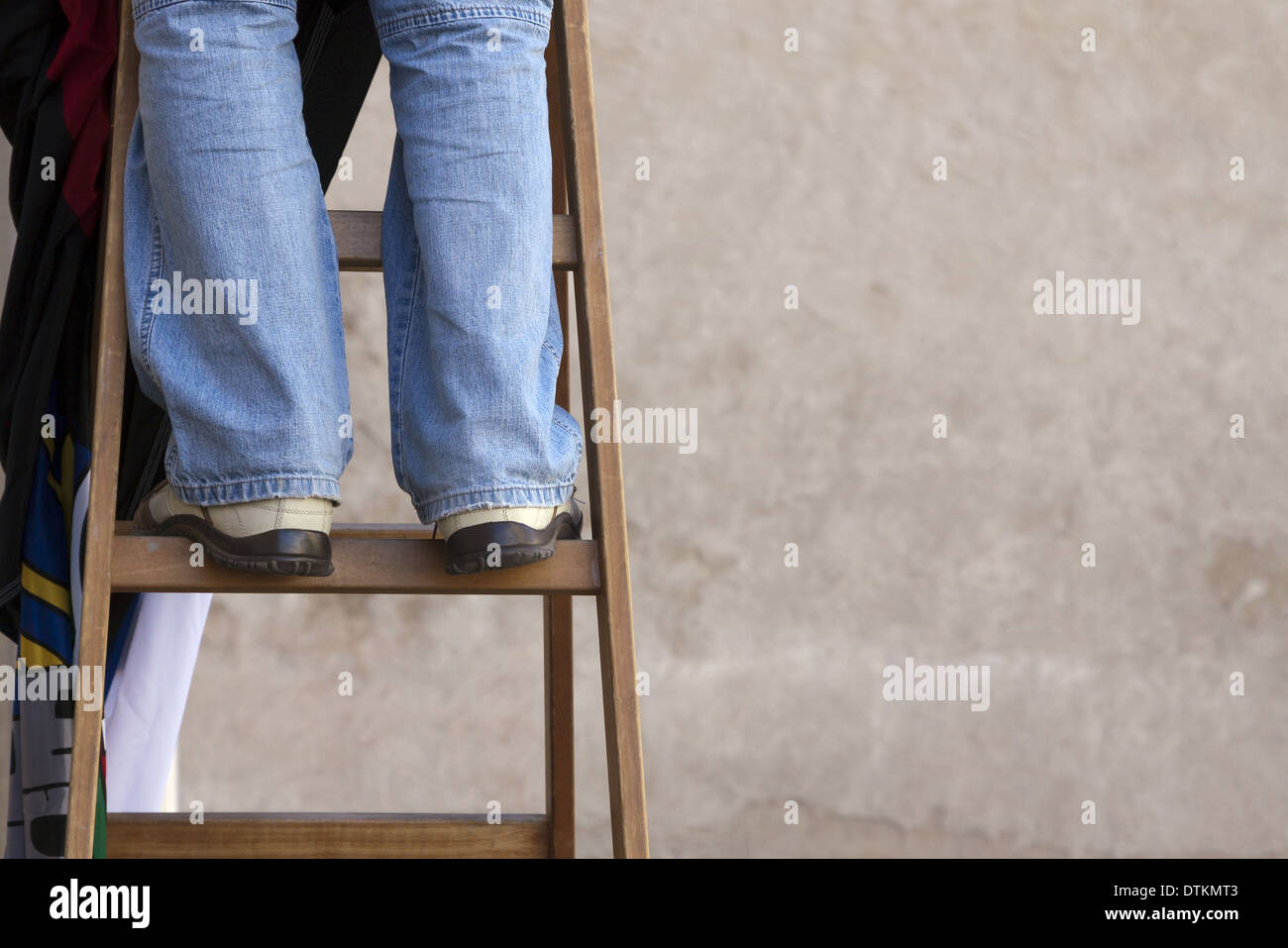 Man stands on a wooden ladder Stock Photo