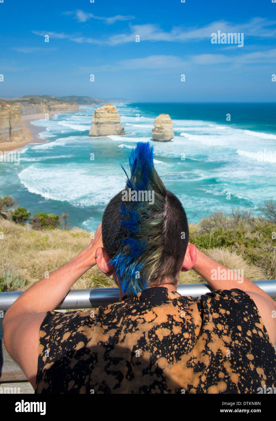 Punk man looking at famous Twelve Apostles landforms on coast of Victoria in Australia Stock Photo
