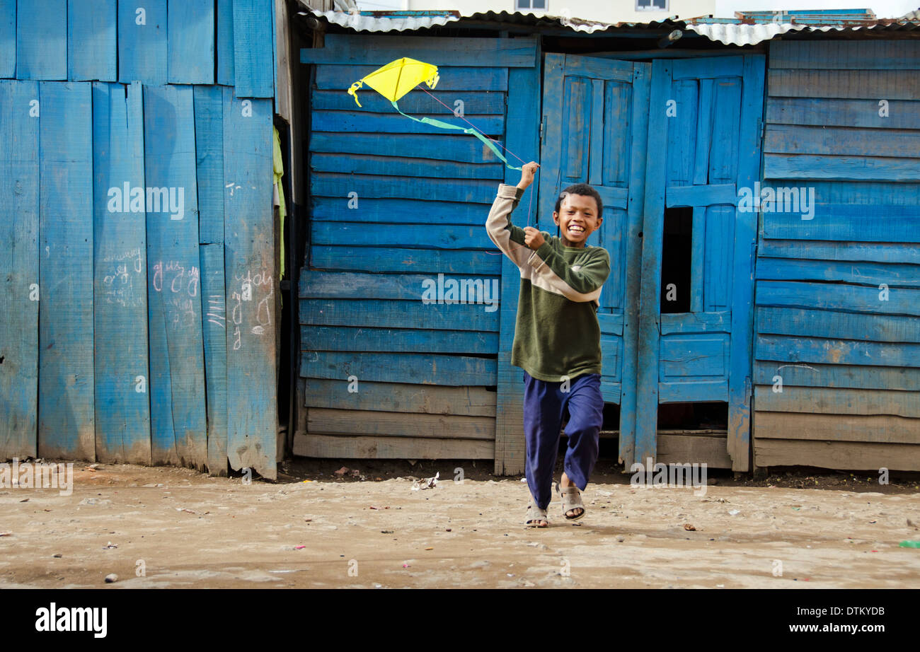 Madagascar, Antananarivo, young boy flying a kit in the courtyard of school Stock Photo