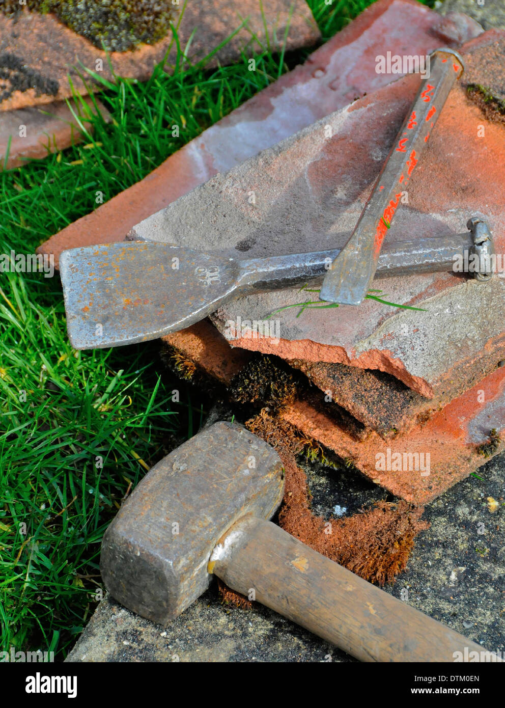 Roofer workman repairing storm damage to a tiled roof tools Stock Photo