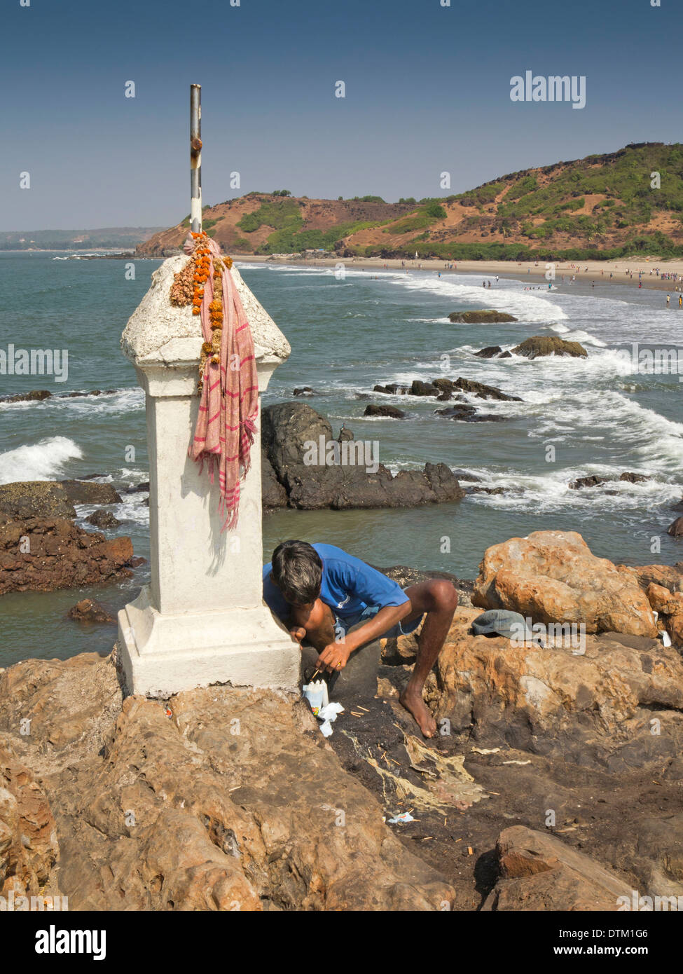 India, Goa, Vagator beach, fisherman lighting candles at Catholic Christian shrine Stock Photo