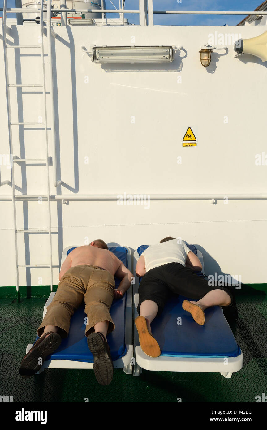Cruise ship passengers asleep on deck Stock Photo
