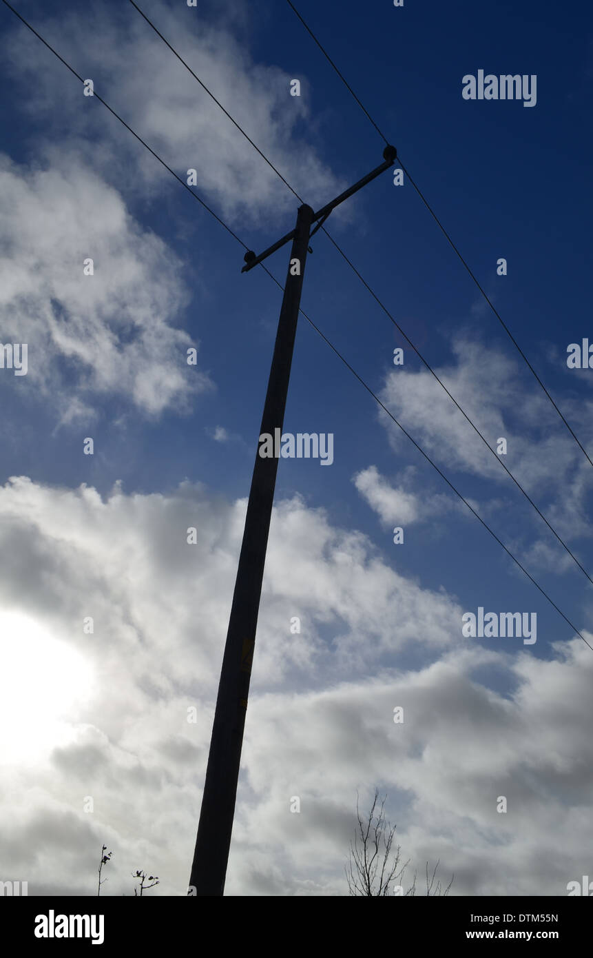 Electricity pole under clouds and blue sky. Stock Photo