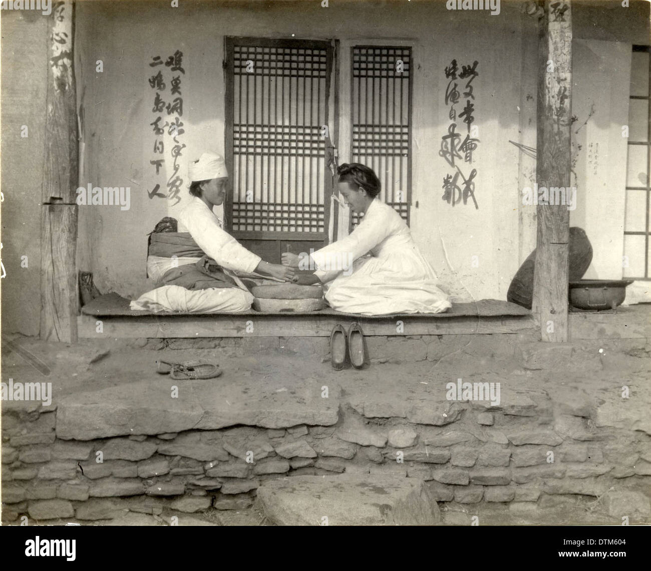Two women grinding at the mill, Korea, (s.d.) (Taylor b Stock Photo Alamy