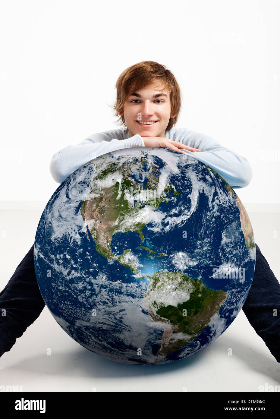 Young man resting over a small planet earth Stock Photo - Alamy