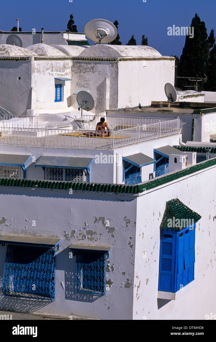 Tunisia, Sidi Bou Said. Rooftop Sun Bathing, Reading. Enclosed 'Harem Window' Lower Right. Stock Photo