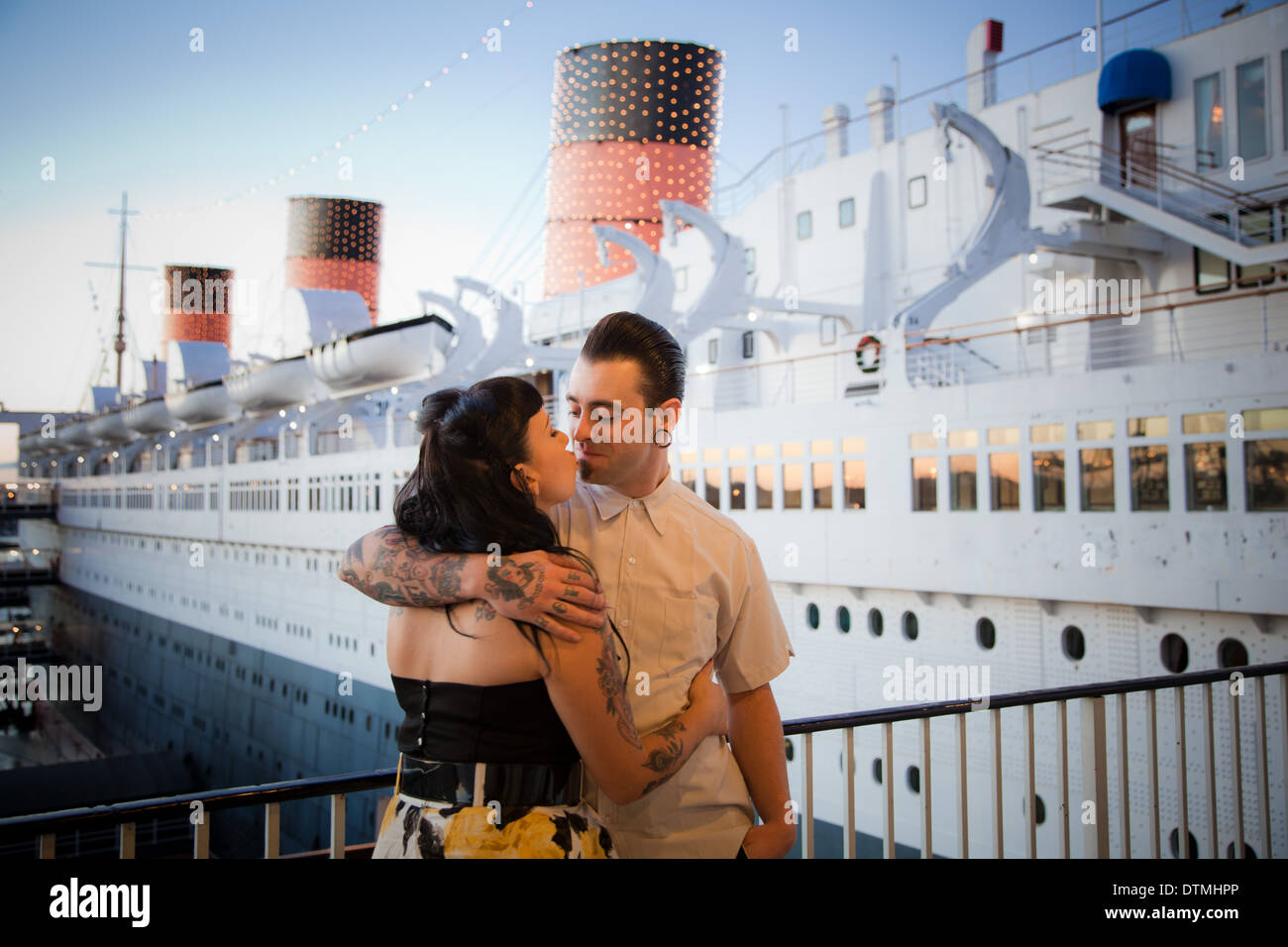 rockabilly couple love snuggle cuddle each other at the queen mary in long beach california on a boat Stock Photo