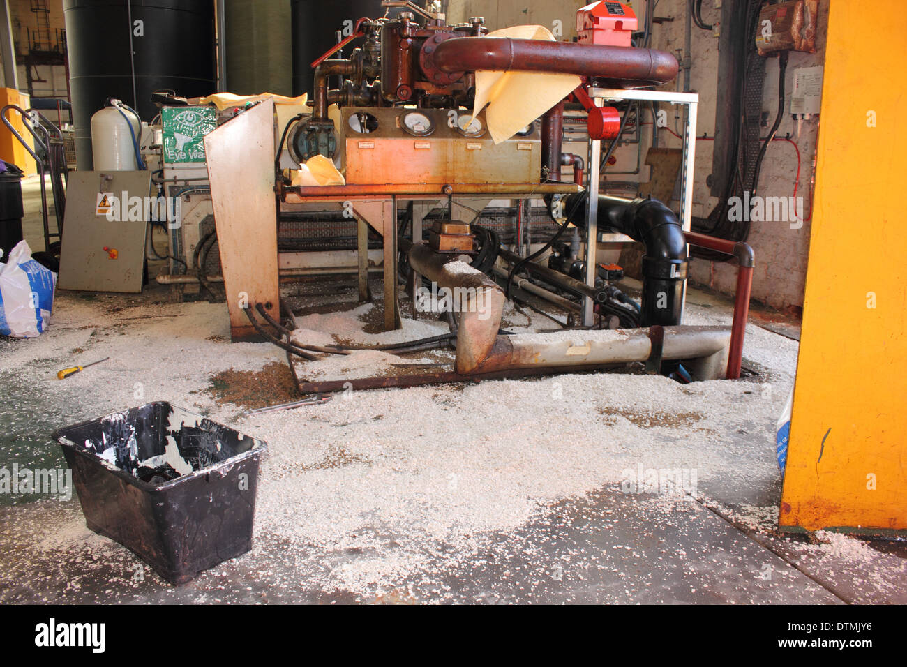 A Diesel fuel spill in a boilerhouse with absorbent pads and granules soaking up and containing the spillage Stock Photo