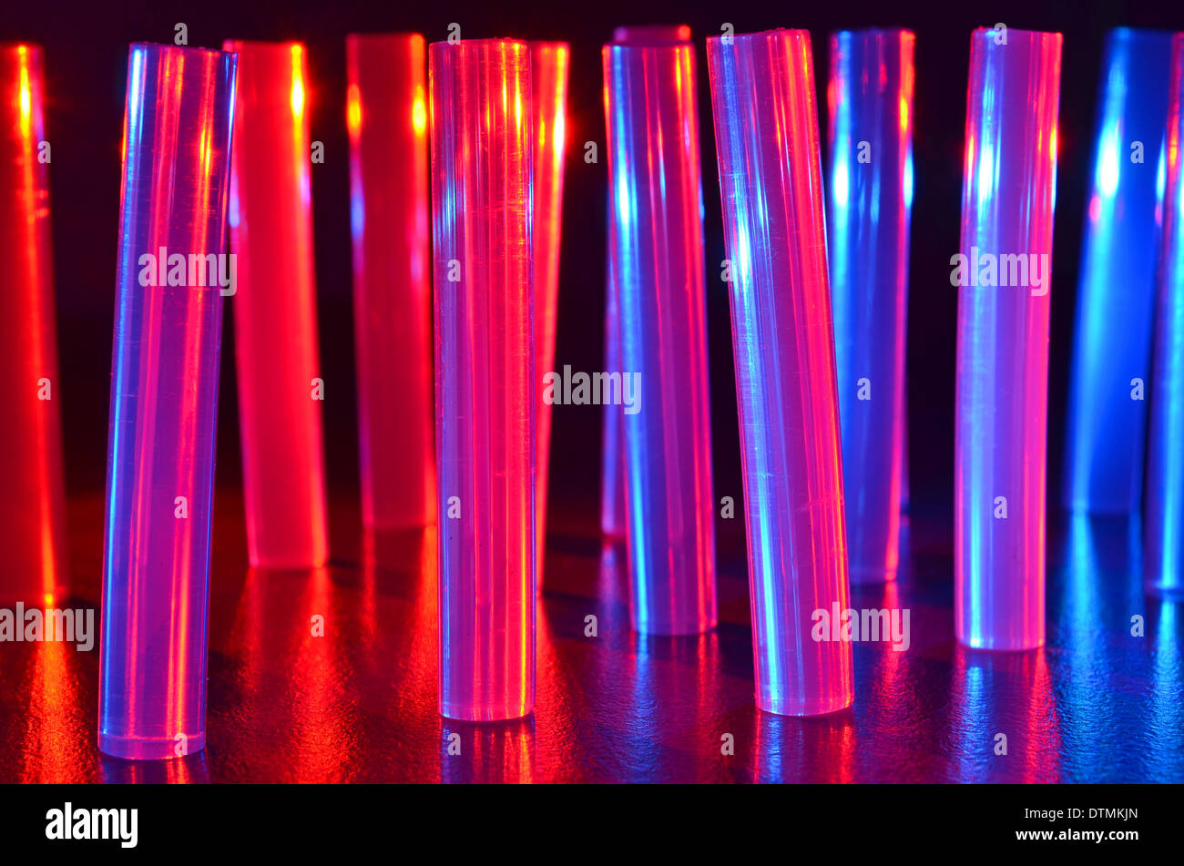 Glue gun sticks standing on end and lit with red and blue LED lights Stock Photo