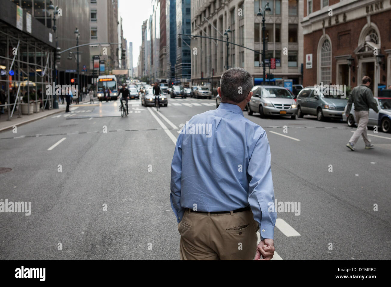 Businessman in blue shirt crossing an intersection. Stock Photo