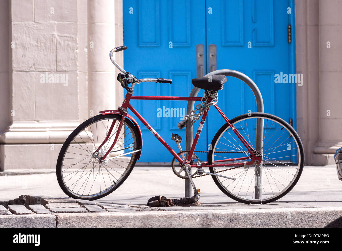 Red bicycle chain to bike parking place. Stock Photo