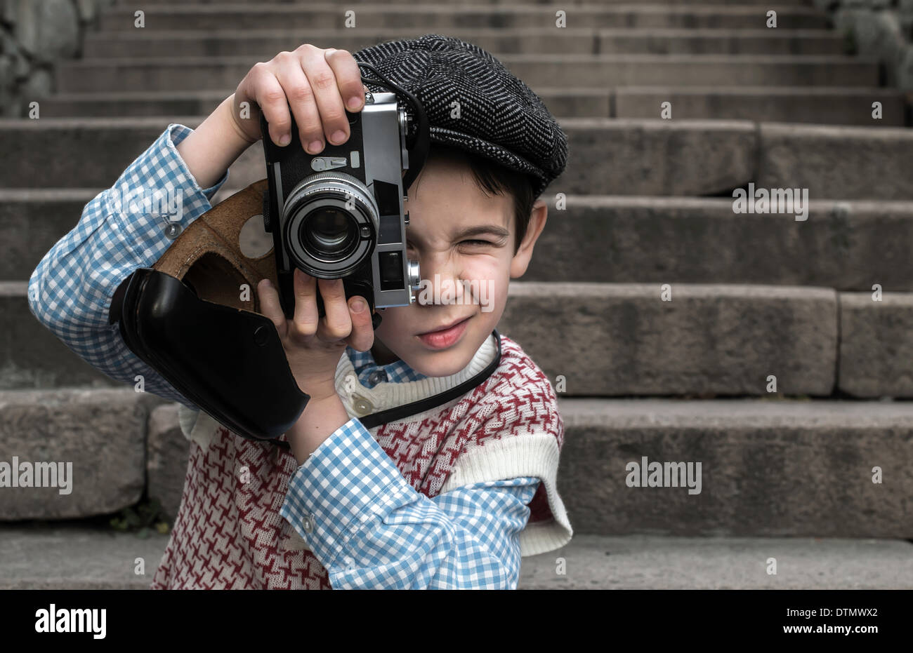 Child with vintage camera. Exterior stairs Stock Photo