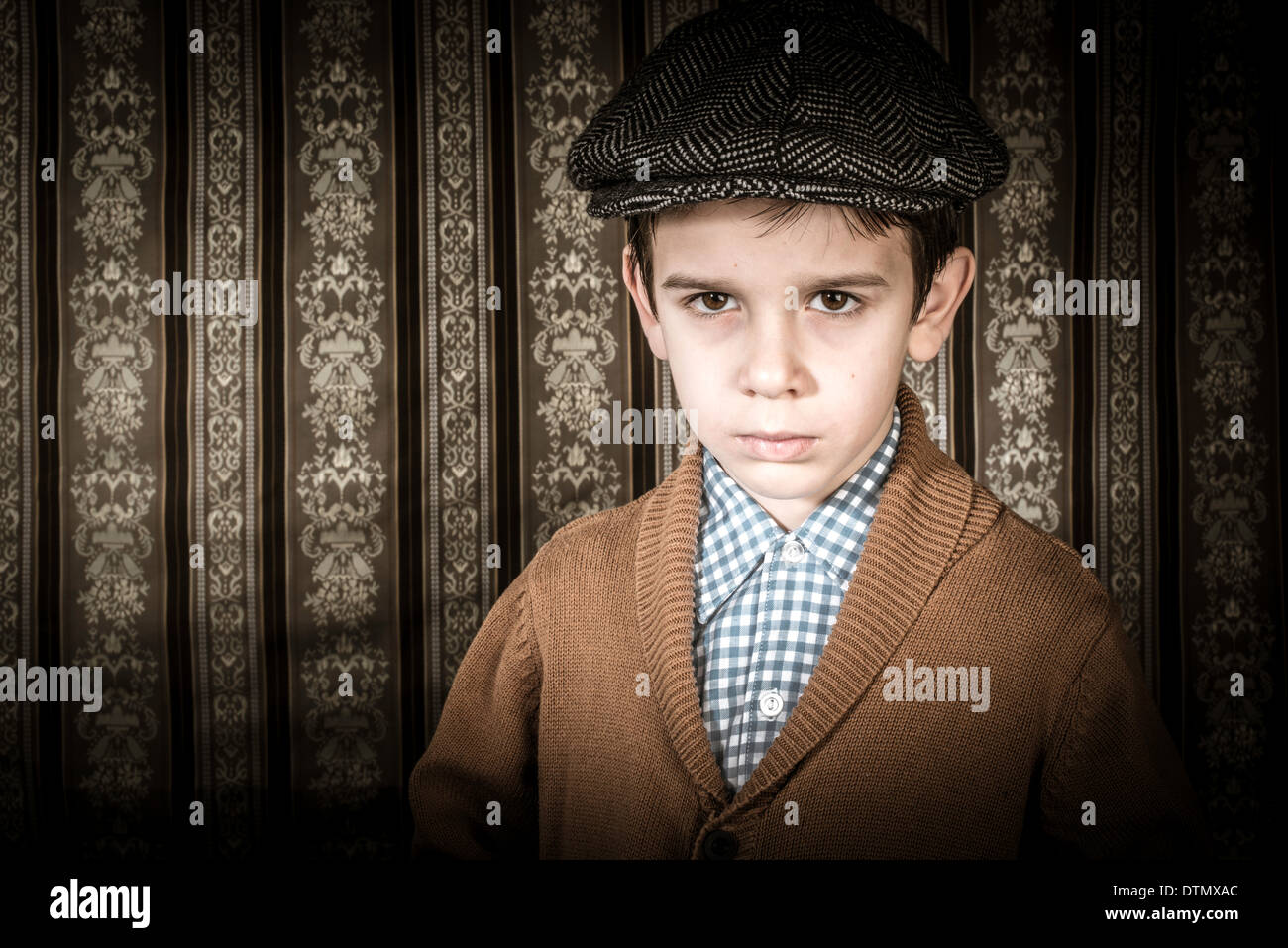 Frowning child in vintage clothes and hat. Close up shot Stock Photo