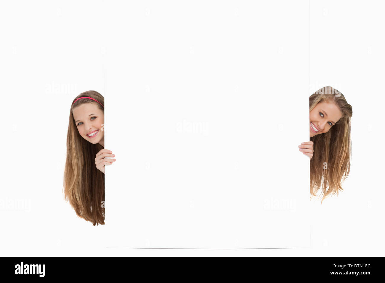Two long hair women behind a blank sign Stock Photo - Alamy