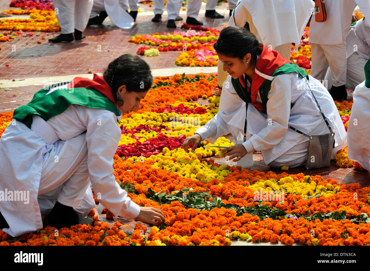 Dhaka, Bangladesh. 21st Feb 2014.  Volunteers decorate Language Martyrs Memorial monument with flowers during the International Mother Language Day in Dhaka, Bangladesh, Feb. 21, 2014. People pay tributes every year to the language movement martyrs, who sacrificed their lives for establishing Bangla as a state language of then Pakistan in 1952. United Nations Educational, Scientific and Cultural Organization declared Feb. 21 the International Mother Language Day on Nov. 17, 1999 to honor the supreme sacrifice of language martyrs. (Xinhua) Credit:  Xinhua/Alamy Live News Stock Photo
