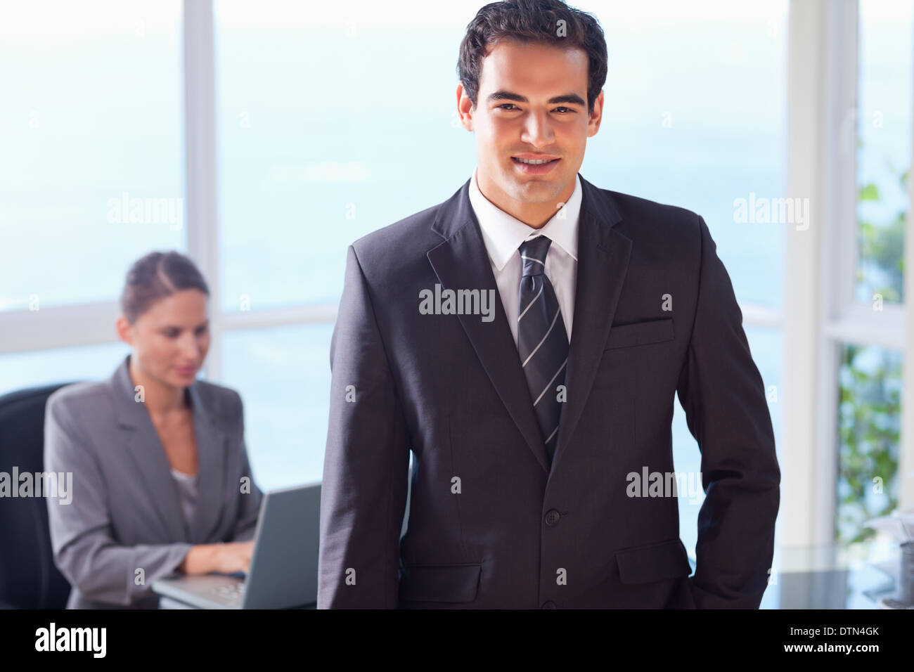 Smiling businessman with colleague behind him Stock Photo - Alamy