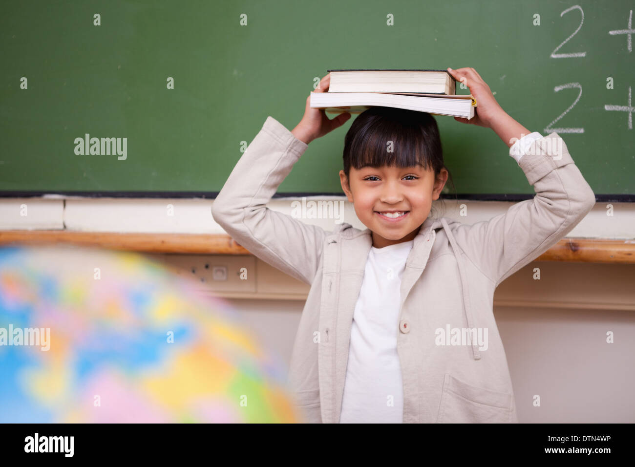Schoolgirl holding her book on her head Stock Photo - Alamy