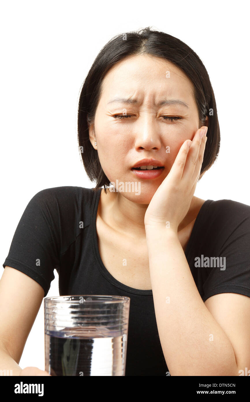 Young Asian woman with tooth pain on white background Stock Photo