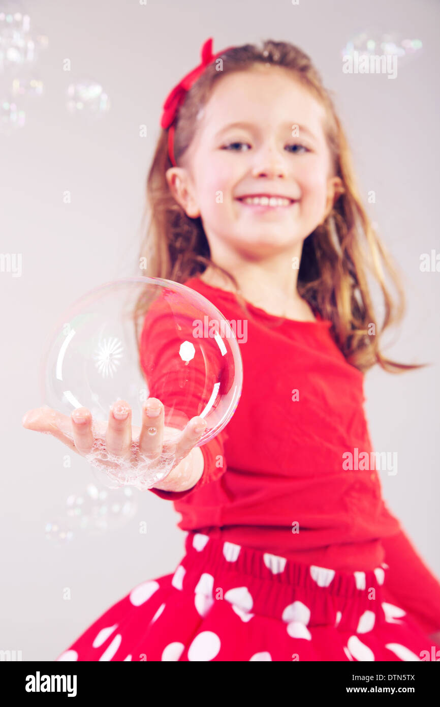 Little woman making large soap bubbles Stock Photo