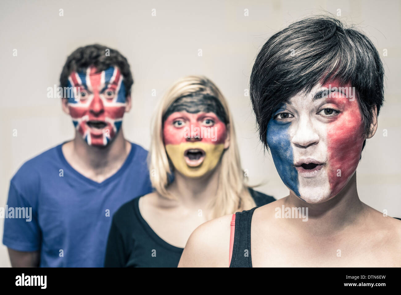 Group of surprised happy people with painted flags on their faces. Stock Photo
