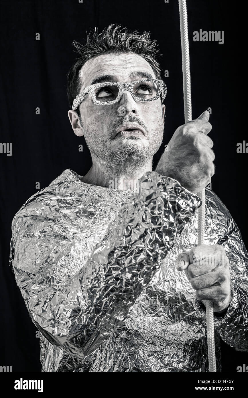 Desperate spaceman holding rope. Stock Photo