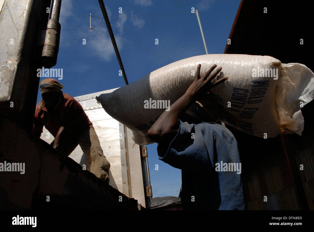Men load large sacks of maize into a truck at a World Food Programme