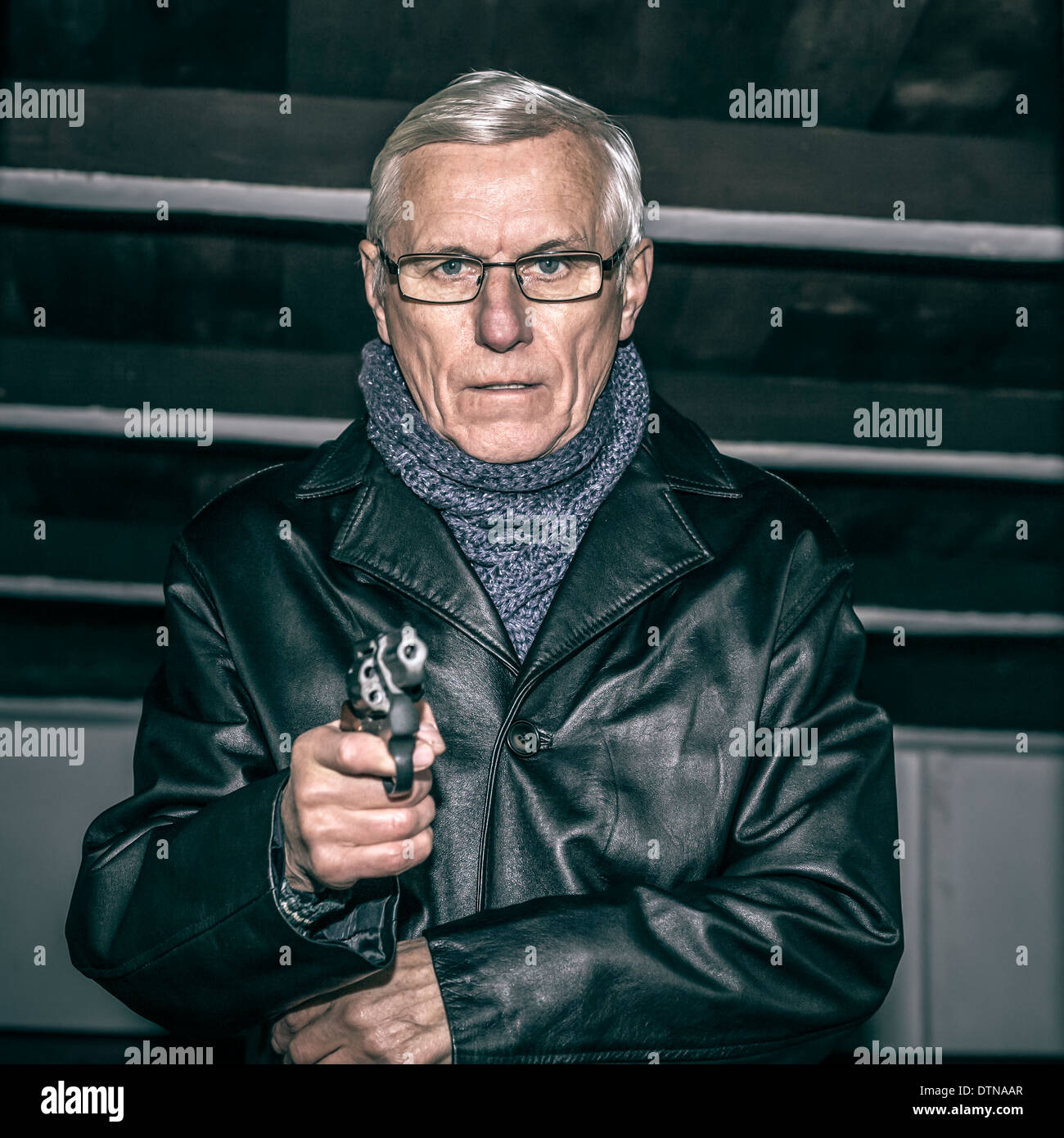 Portrait of dangerous senior man aiming a gun at you. Stock Photo