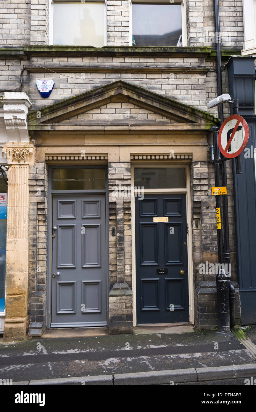 Grey & blue wooden front doors of flats in Malton North Yorkshire