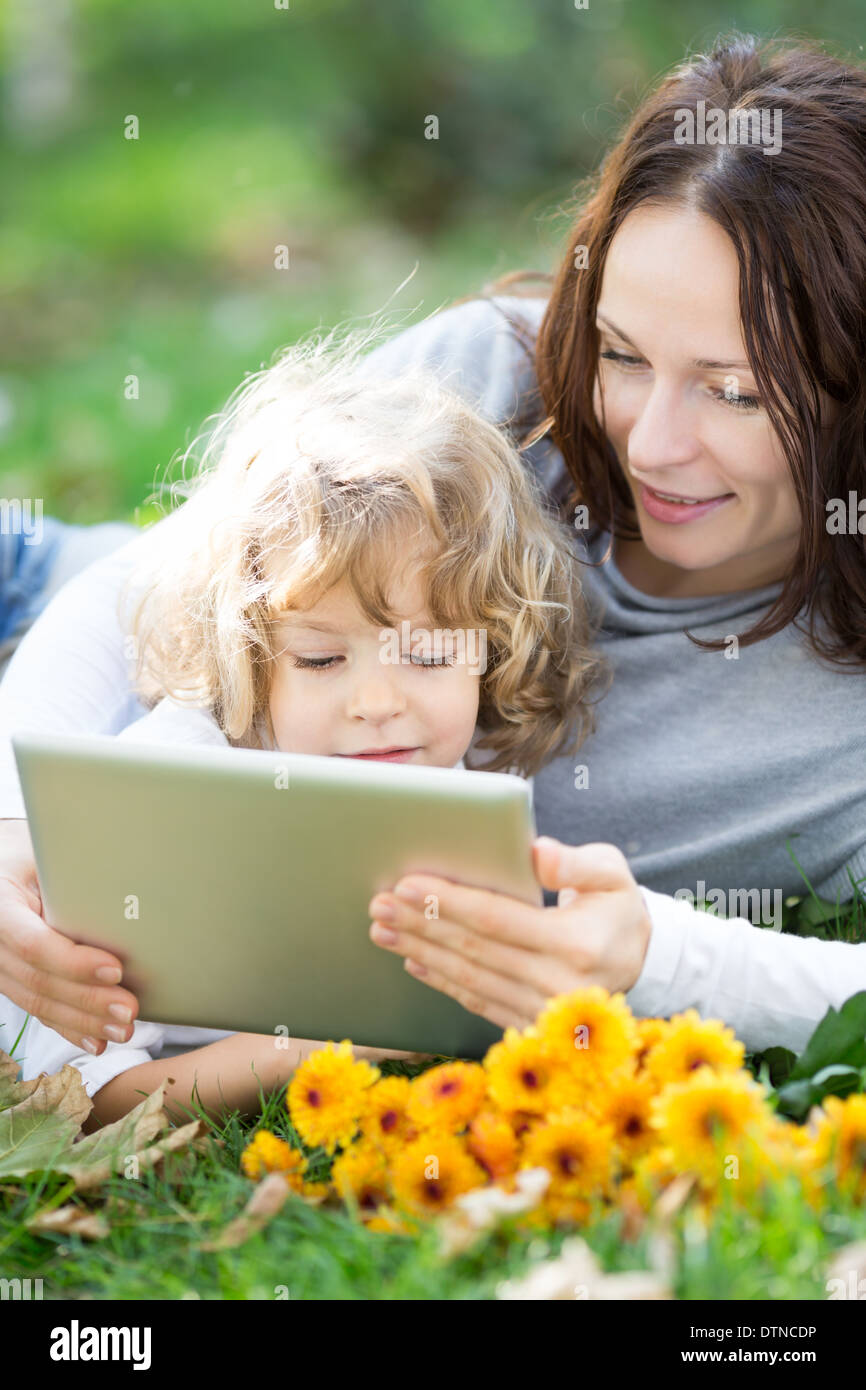 Family using tablet PC outdoors Stock Photo