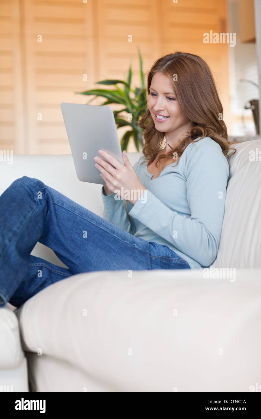 Smiling woman on the sofa with her tablet Stock Photo - Alamy