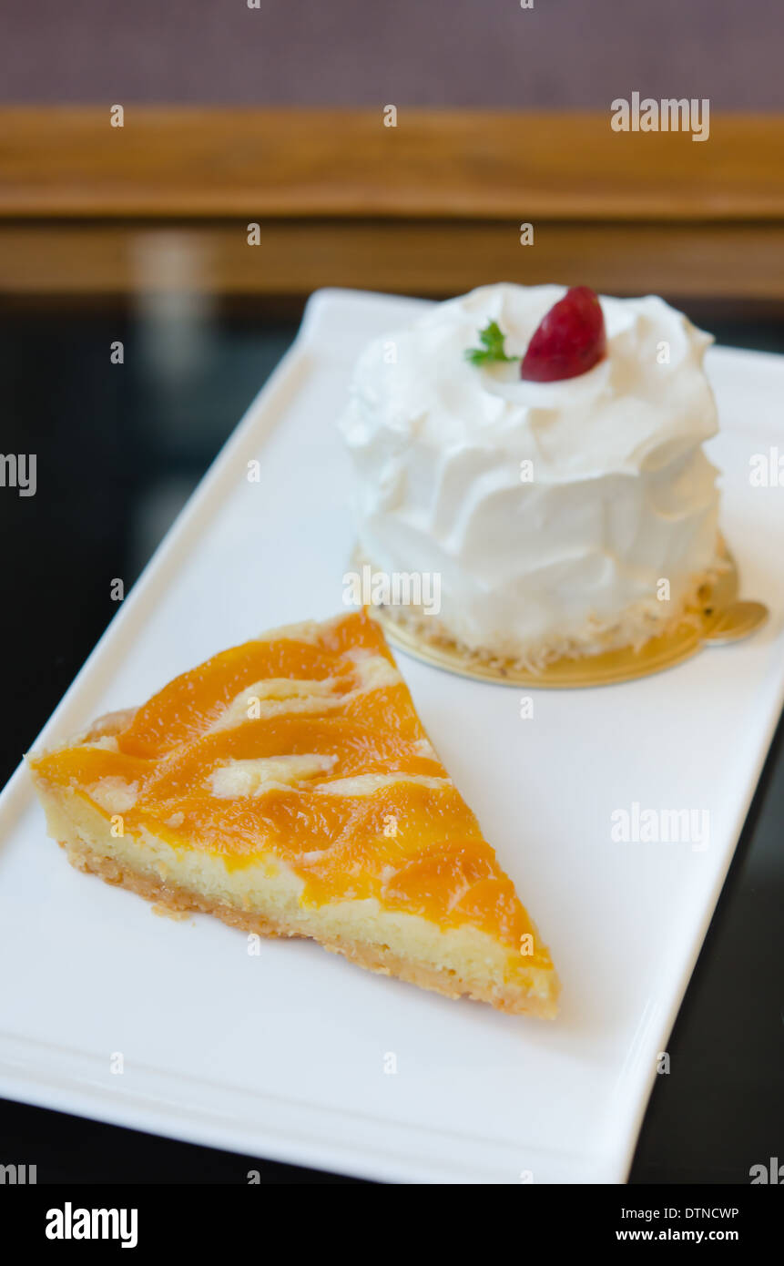 young coconut cake and peach tart on dish Stock Photo