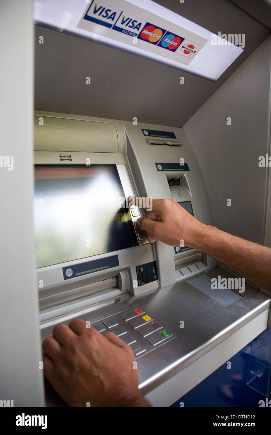Man using cash machine in Europe to withdraw cash Stock Photo