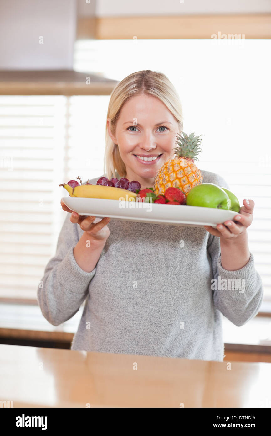 Woman presenting plate of fruits Stock Photo