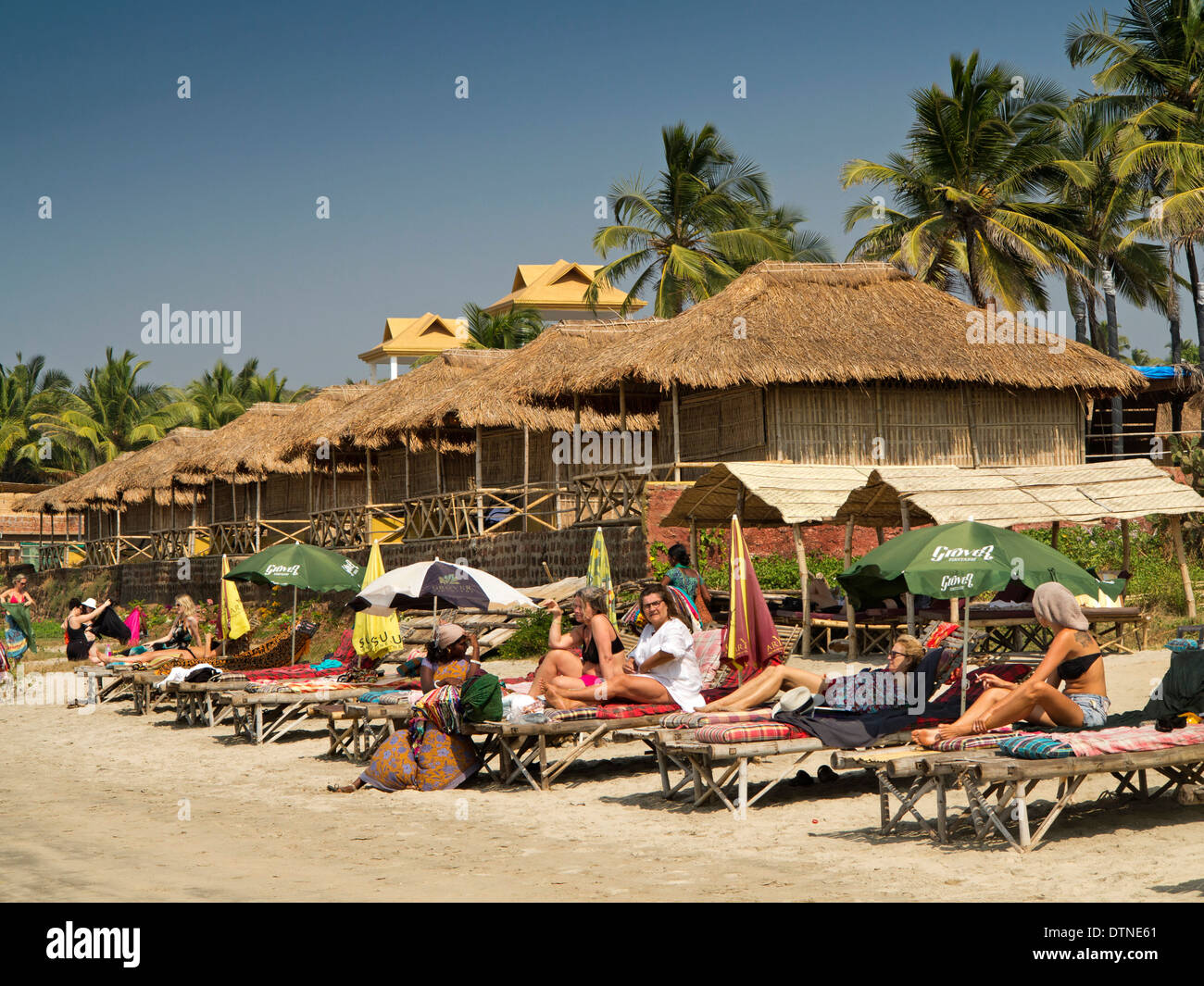 India, Goa, Mandrem beach, tourists sunbathing on sunloungers Stock Photo