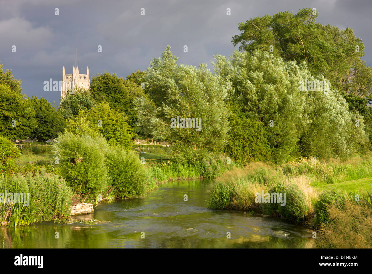 Evening sunlight illuminates Fairford Church and the River Coln in the Cotswolds, Gloucestershire, England. Summer (July) 2010. Stock Photo