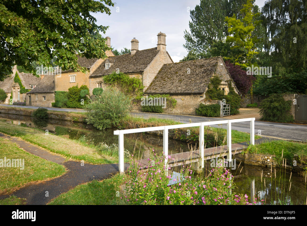 Cottages and footbridge over the River Eye in the Cotswolds village of