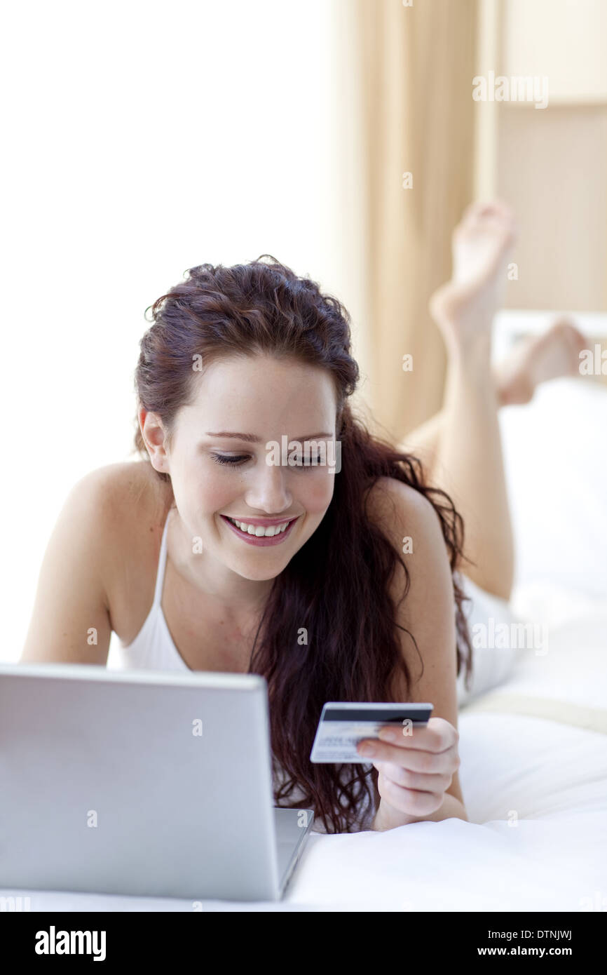 Beautiful woman lying in bed shopping online Stock Photo Alamy