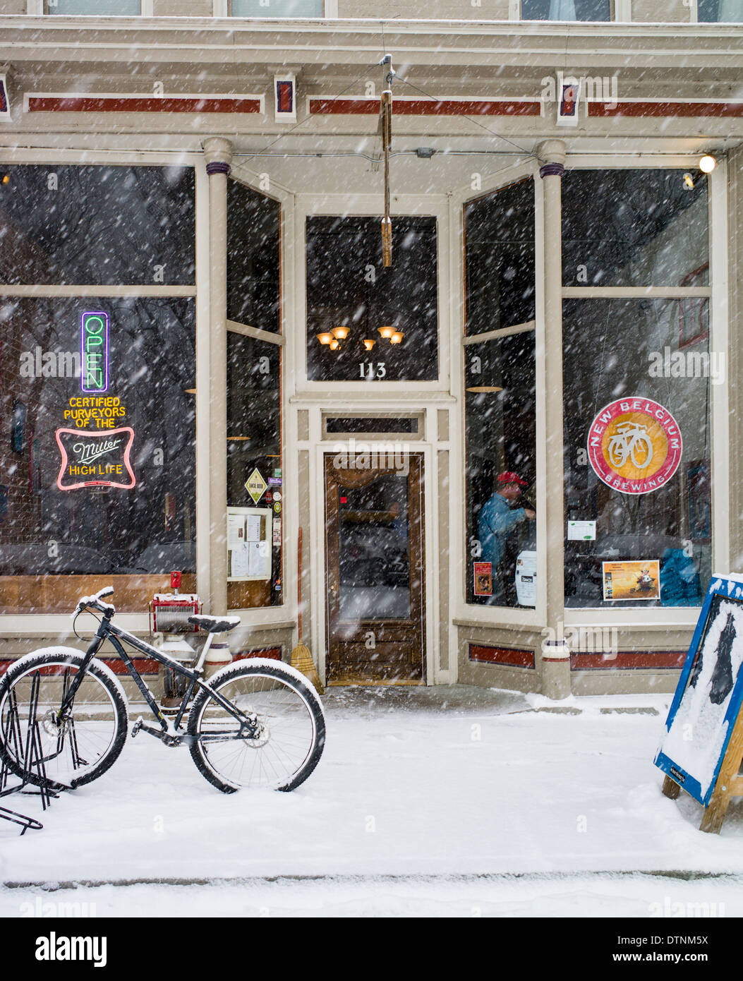 Snowy winter view of bicycle outside a cafe in historic downtown Salida, Colorado, USA Stock Photo