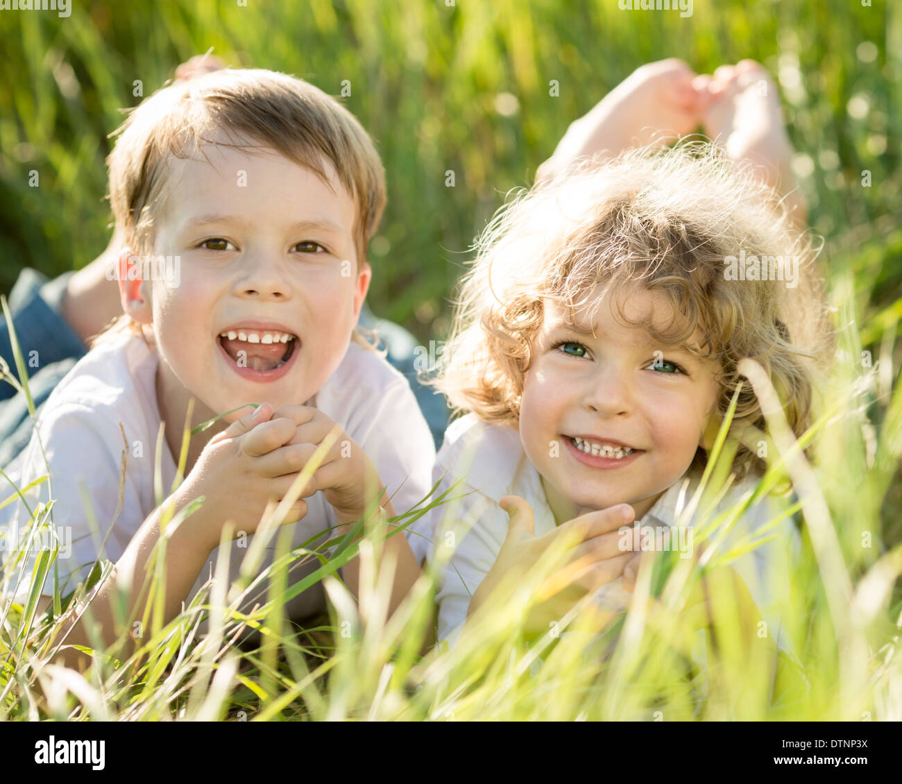 Happy children lying on grass Stock Photo